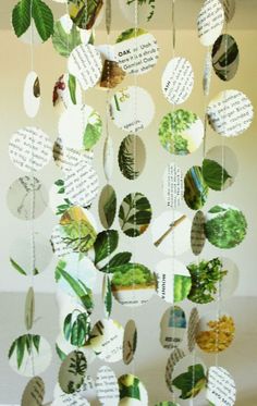 a wind chime made out of paper with leaves and words hanging from the ceiling