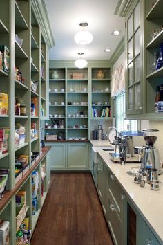 a kitchen filled with lots of green cupboards and counter top space next to a coffee maker