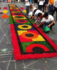 two people are painting on the ground with flowers