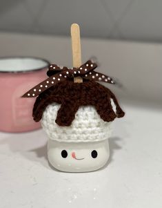 there is a small cupcake with a bow on it and a wooden stick sticking out of it