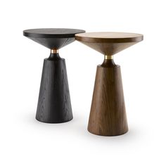 two wooden stools sitting next to each other on a white surface, one black and one brown