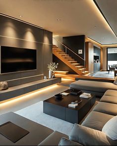 a living room with couches and a television on the wall in front of stairs