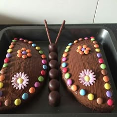 a chocolate butterfly cake sitting on top of a baking pan covered in candy and candies