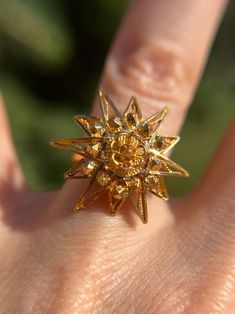 This a beautiful piece of art by a jeweler at some point. The artist has created a beautiful sunburst and it rests atop a comfort band. It's actually quite comfortable to wear.  The sun is a .9" round face and sits .3" (or 8.5mm) off the finger.  It is currently sized 4.5 and resizable. The band is a 3mm band.  No markings but tests 18k.  Weighs 6.77g Formal Yellow Gold Starburst Jewelry, Elegant Yellow Gold Sun-shaped Jewelry, Elegant Sun-shaped Yellow Gold Jewelry, Formal Gold Starburst Jewelry, Gold Starburst Ring As A Gift, Elegant Sunburst Jewelry With Sun And Moon Design, Elegant Sunburst Jewelry With Sun Design, Elegant Sun And Moon Design Sunburst Jewelry, Elegant Starburst Sun Design Jewelry