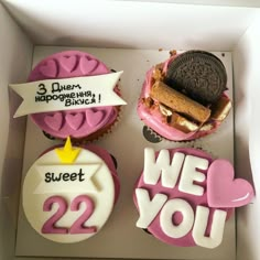 two decorated cupcakes in a box with the words we love you written on them