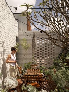 a woman standing next to a table in a garden