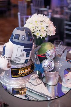 a star wars themed centerpiece on a table with flowers and other items around it