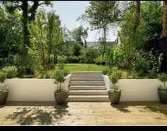 a wooden deck with planters and stairs