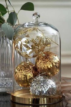 three golden balls under a glass dome on a table