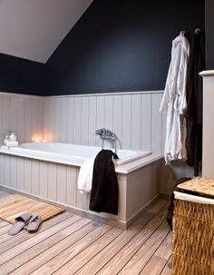 a large white bath tub sitting next to a wooden floor