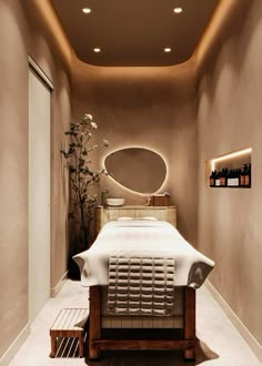 a spa room with a large mirror above the bed and lights on the wall behind it