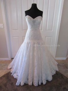 a white wedding dress on display in front of a door