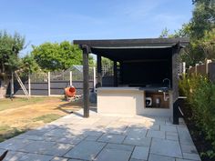 an outdoor bbq grill in the middle of a yard