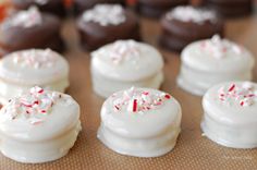 white frosted cookies with sprinkles and candy canes on a baking sheet