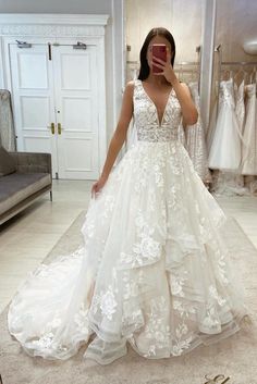 a woman is taking a selfie in her wedding dress while looking into the mirror