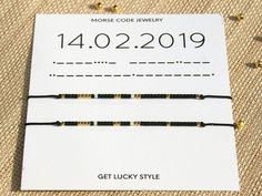 three black and gold beaded bracelets sitting on top of a white piece of paper