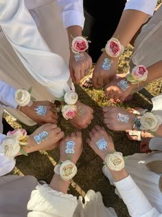 a group of people standing in a circle with their hands painted white and holding flowers