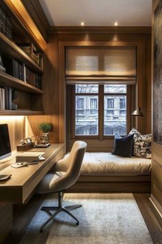 a room with a bed, desk and computer on the table in front of a window