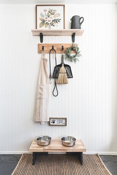 a dog bowl and two bowls on a wooden table in front of a white wall