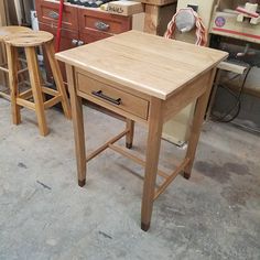 two wooden stools sitting next to each other in a room filled with woodworking tools