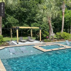 an empty swimming pool with lounge chairs and trees in the backgroung area