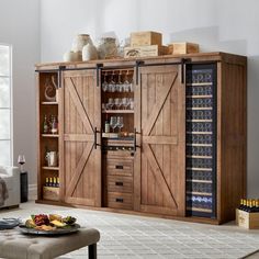 a large wooden cabinet with wine glasses and bottles on it in a living room next to a couch