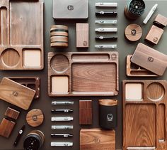 various wooden and metal items are arranged on a table top, including knives, spoons, plates, cups, and bowls