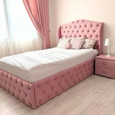 a bedroom with pink furniture and curtains