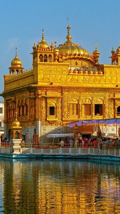 an ornate golden building sitting on top of a lake