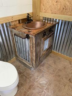 a bathroom with a toilet, sink and corrugated metal wall panels on the walls behind it