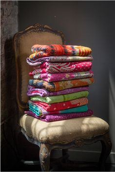 a stack of colorful towels sitting on top of a chair