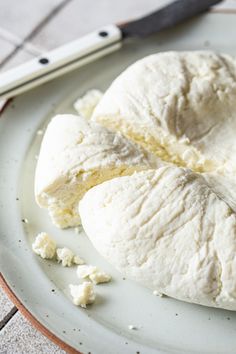 two pieces of bread sitting on top of a white plate next to a knife and fork