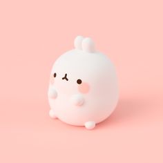 a small white object with black eyes on a pink background, it looks like an animal