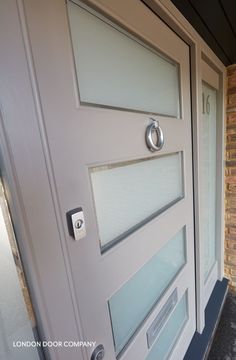 a close up of a door with glass panels on the outside and brick wall in the background