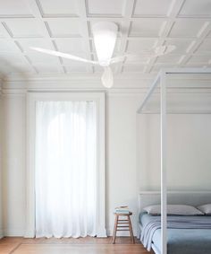 a bedroom with white walls and wooden floors