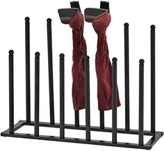 two pairs of red pants hanging from black metal poles with one pair in the middle