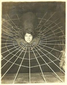 an old black and white photo of a woman in a spider web