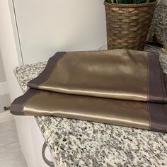 a brown and tan blanket sitting on top of a counter next to a potted plant