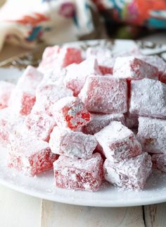 a white plate topped with sugar cubes covered in powdered sugar