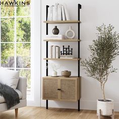 a living room with a white couch and book shelf next to a potted plant