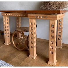 a wooden table sitting on top of a hard wood floor next to a planter