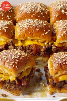 several cheeseburger sliders stacked on top of each other with melted cheese and ground beef