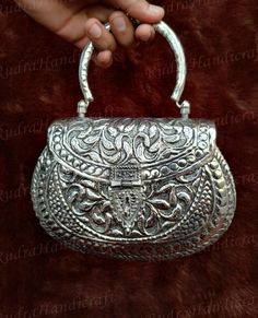 Size:   Height- 5.5 Inch, Width - 7.5 Inch, Depth - 2 inch , Handle Length- 3.5 Inch Weight - 460 grams Made by Brass Metal and Silver Coated, Inner side is Velvet coated and bag have Movable Handle. Handmade Vintage Hand Clutch made from Brass Metal . A basic Brass metal object is fist designed and fine carving is done on it by hand. The process is finally completed by oxidization and polishing. The clutch is fixed with Metal Handle and the opening is big enough and the wall of the inner space is also fixed with soft velvet to protect your items. Such metal clutch bags is a very old art and but they are recently been introduced as a fashion statement Design by craftsman by cutting metal in frame and Beautiful Fine carving is done on it by hand. Specially designed Vintage bag for Party, Fu Hand Clutch, Metal Purse, Silver Party, Metallic Purse, Velvet Coat, Bag Silver, Silver Coat, Unique Bags, Antique Metal