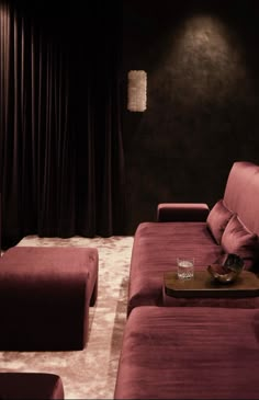 a living room with purple couches and black walls