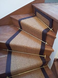 a set of stairs with black and tan carpet