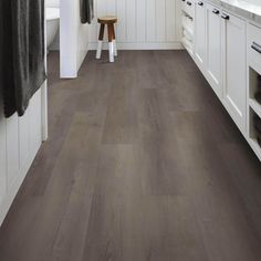 a kitchen with white cabinets and wood flooring