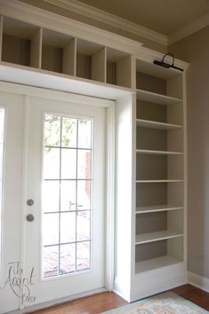 an empty room with open bookcases and a door