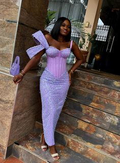 a woman in a purple dress standing on steps