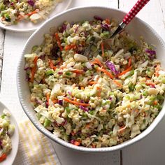 two bowls filled with coleslaw and carrots on top of a white table