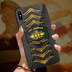 a woman holding up her phone case with the vietnam army emblem on it